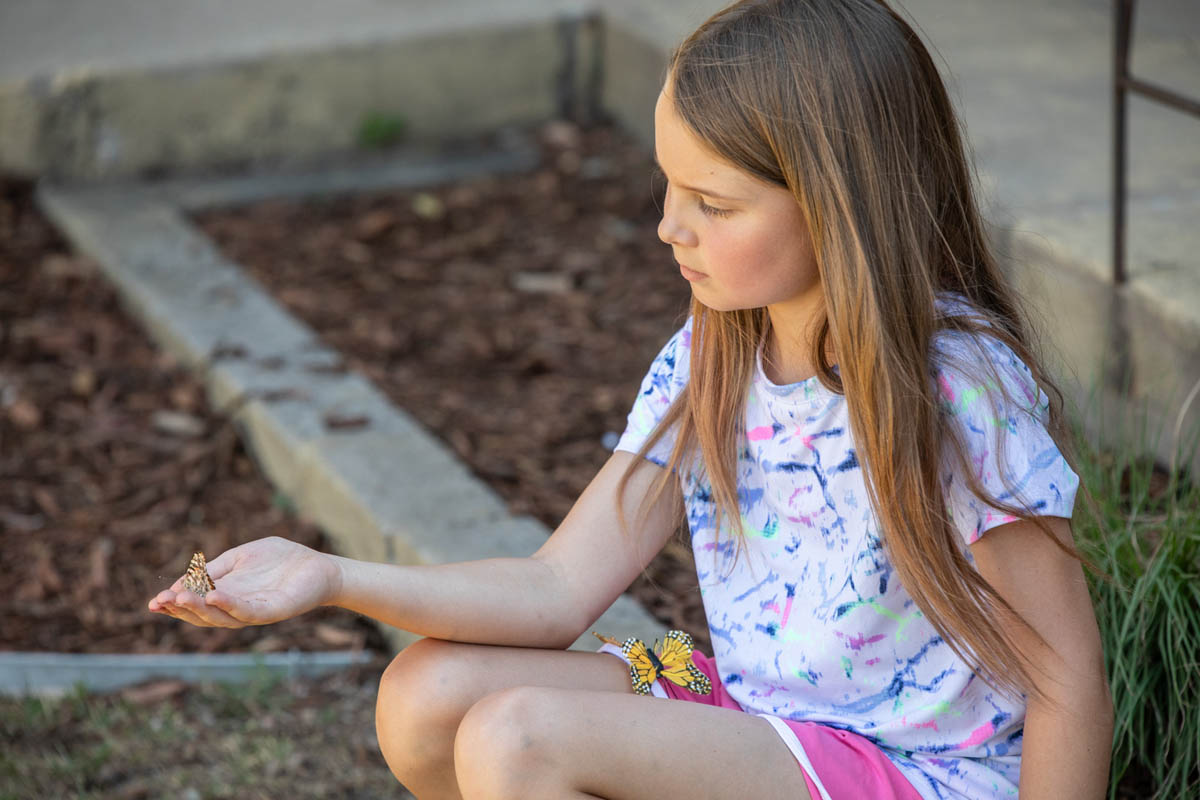 A child kneeling beside a freshly prepared garden bed